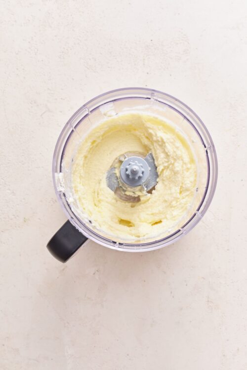 Creamy butter and sugar mixture in food processor for baking recipes.