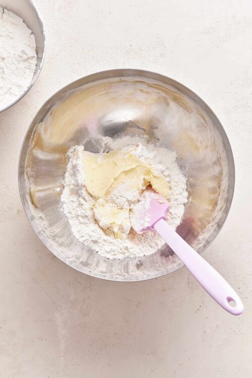 Flour, butter, and dough mixture in a mixing bowl for baking.