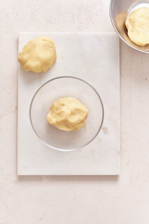 Soft, smooth pie dough balls on a white marble cutting board, ready for rolling or baking - perfect for homemade baking.