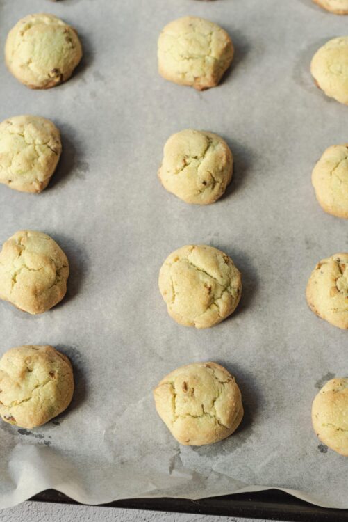 Butter cookies on baking sheet with parchment paper, homemade baked goods, golden cookies with cracks, delicious sweet treats, bakedbree recipes.