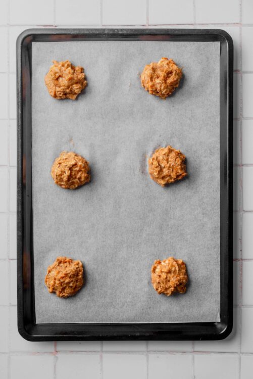 Soft cookie dough balls on baking sheet for baking cookies.