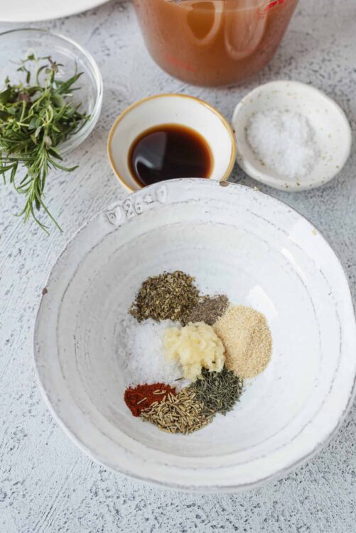 Ground spices and herbs in a white ceramic bowl for cooking and seasoning recipes.