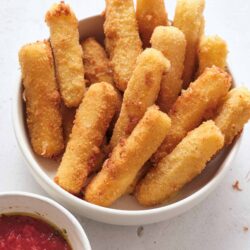 Crispy homemade mozzarella sticks with marinara dipping sauce. Easy appetizer recipe for parties and snacks.