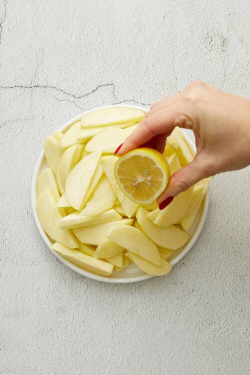 Sliced apples and lemon in a bowl for baking or cooking.