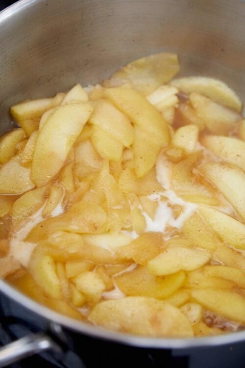 Sliced apples cooking in a saucepan for baking or apple pie recipe.