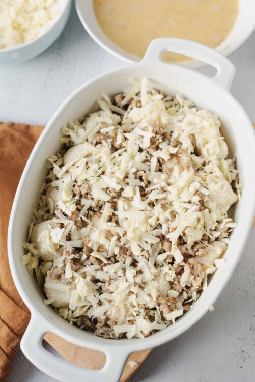 Creamy chicken and cheese casserole baking in a white dish with shredded cheese topping.