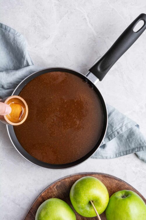 Sweet apple caramel sauce simmering in a skillet, ready for baked apple desserts or snacks.