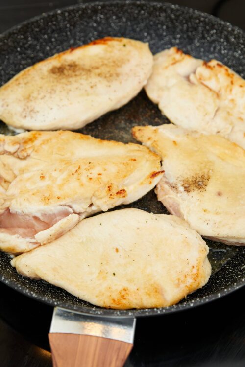 Juicy chicken breasts cooking in a non-stick skillet for easy dinner recipes.