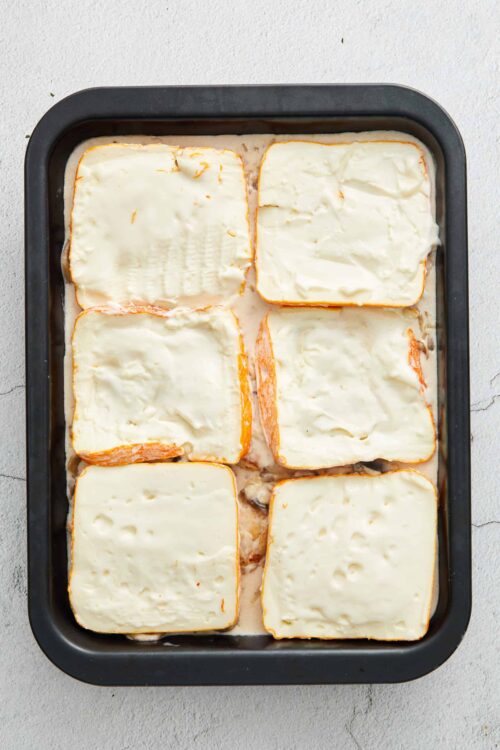 Golden baked cheese lasagna with melted cheese on top, ready to cook.