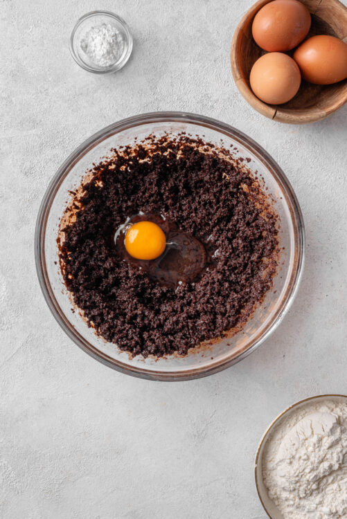 Creamy chocolate cake batter with egg in a mixing bowl for baking recipes.