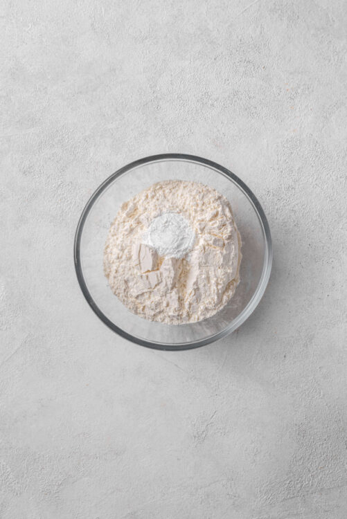 Flour in a glass mixing bowl for baking recipes.