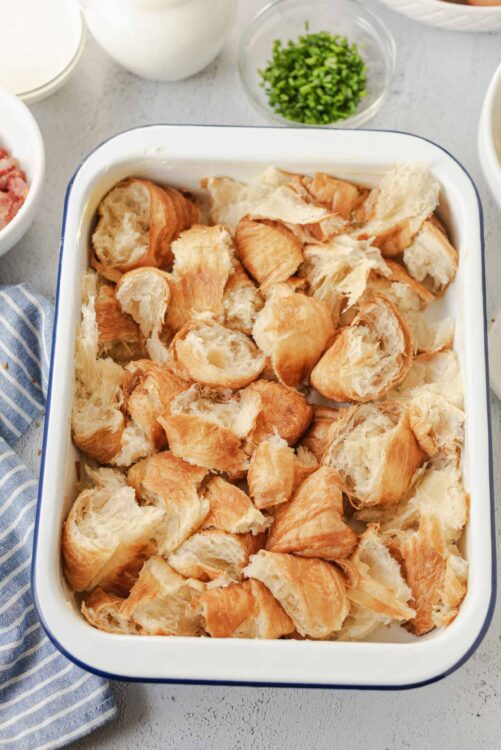 Flaky cooked puff pastry scraps in a white baking dish for baking or recipes.