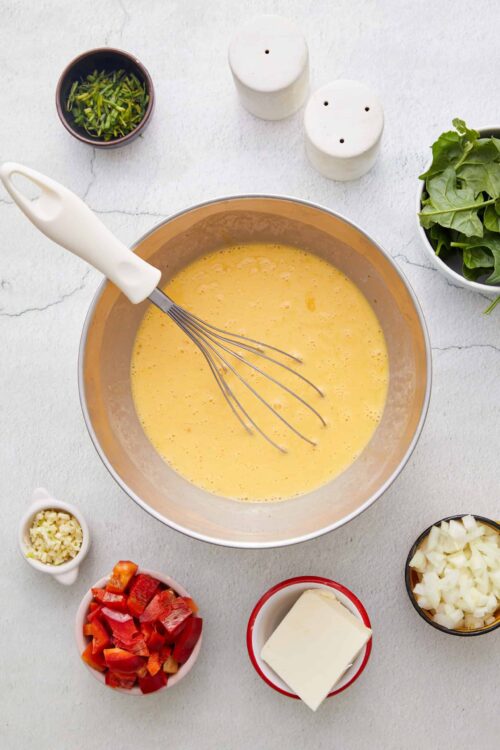 Creamy scrambled eggs with fresh vegetables and herbs for delicious breakfast or brunch recipes.