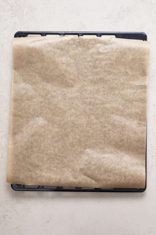 Baking tray with parchment paper ready for baking or cooking recipes.