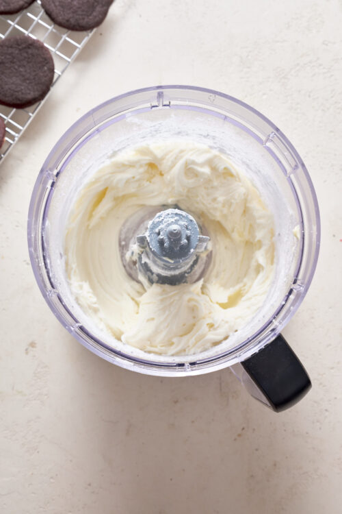 Cream cheese frosting in a food processor, ready for baking. Perfect for cakes, cupcakes, and desserts.