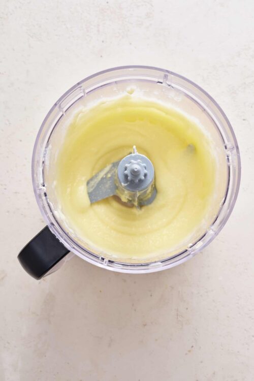 Smoothly blended yellow cake batter in a food processor.
