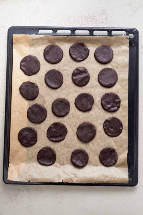 Rich chocolate cookies cooling on a baking tray.