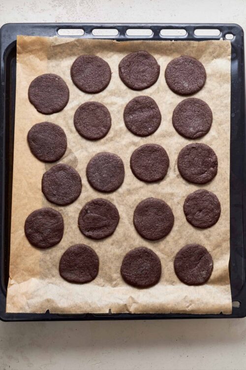 Fudgy chocolate cookies on parchment paper fresh from the oven.