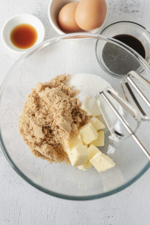 Flour, butter, brown sugar, and sugar in a mixing bowl for baking recipes.