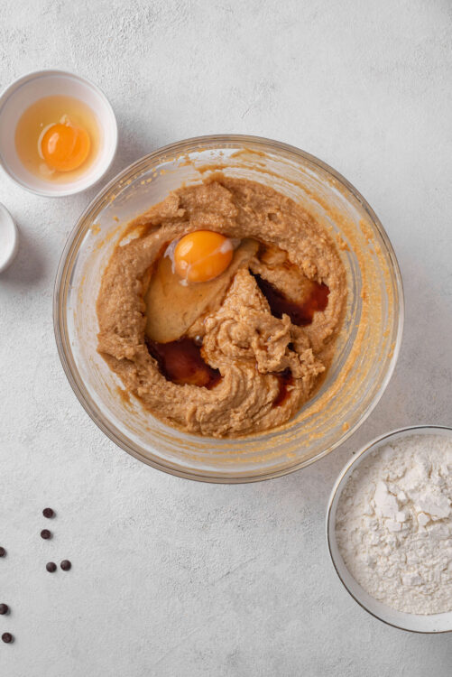 Creamy cookie dough batter with eggs and vanilla in mixing bowl for baking recipes.