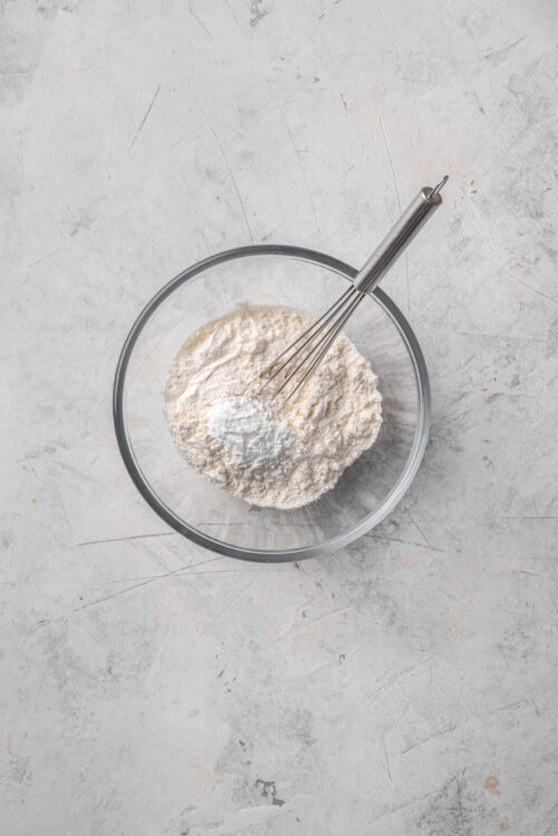 Flour mixture in a glass bowl with a whisk, ready for baking.