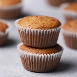 2. Golden brown homemade muffins in paper liners on grey background.