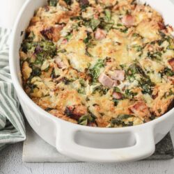 Cheesy chicken and spinach casserole dish in a white baking dish, baked to perfection.
