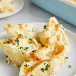 Buttered garlic mashed potatoes with parsley on a white dish.