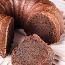 Decadent chocolate pound cake with rich, moist texture on a white serving platter.