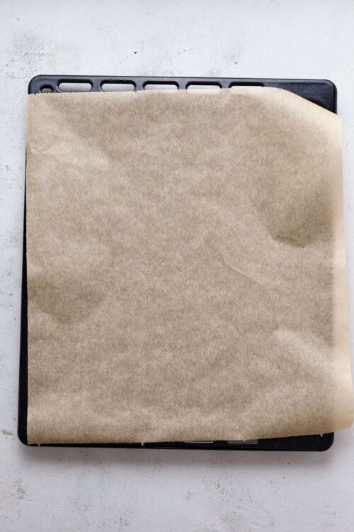 Unbaked pastry on a baking sheet covered with parchment paper for baking.