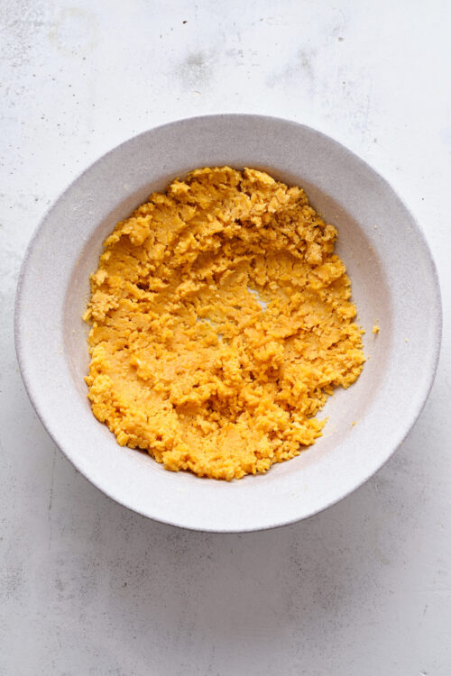 Crushed gluten-free graham crackers in a white bowl for pie crust preparation.