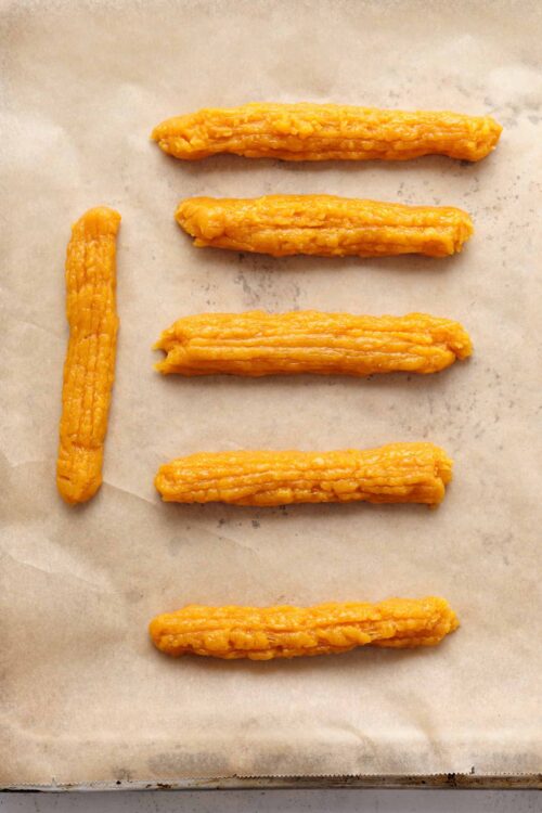 Golden baked crispy pork rinds on parchment paper.