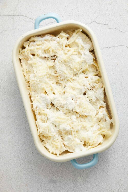 Creamy white cheese casserole baked in a ceramic dish with shredded cheese topping.