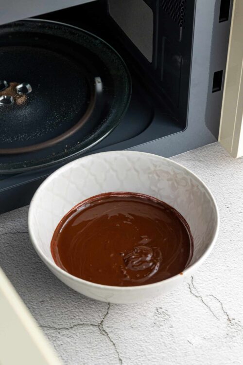 Creamy melted chocolate in a white bowl ready for baking or dessert making.