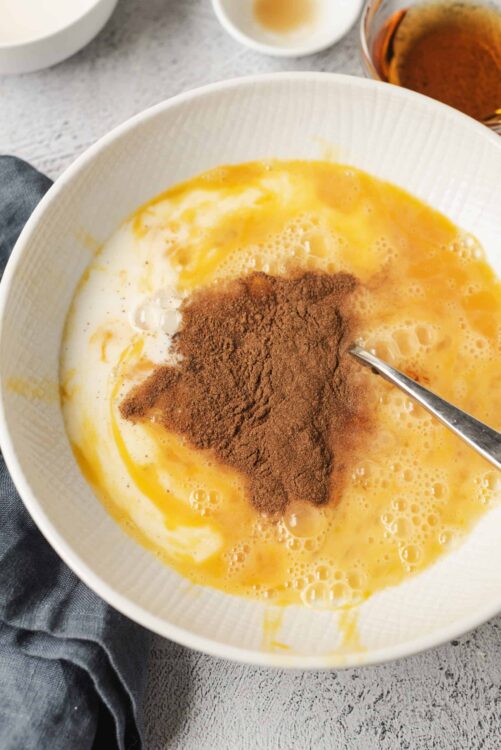 Creamy scrambled eggs with cocoa powder on top, served in a white bowl.
