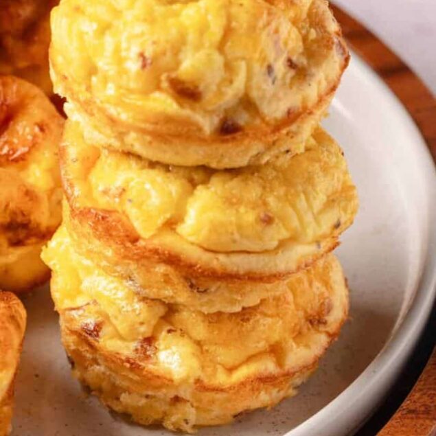 Fluffy cheesy potato muffins on a white plate, baked to golden perfection.
