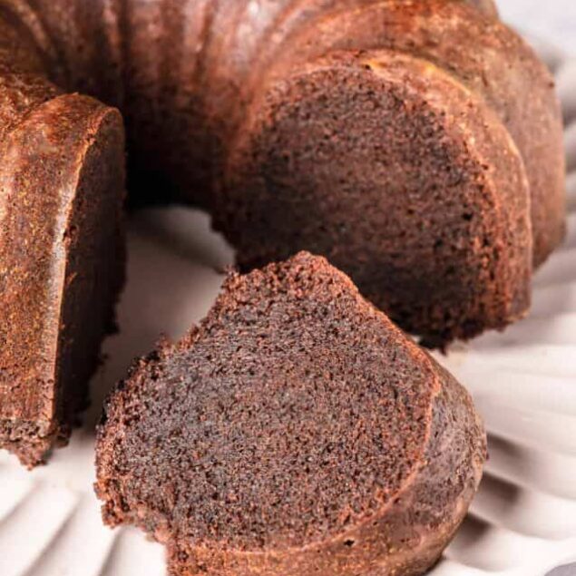 Decadent chocolate pound cake with rich, moist texture on a white serving platter.