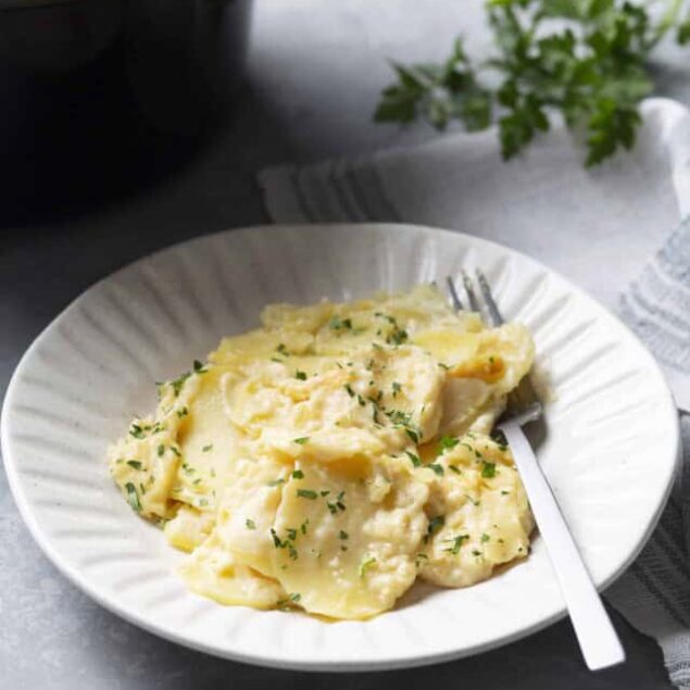 Creamy mashed potatoes with herbs served on a white plate, perfect comfort food.