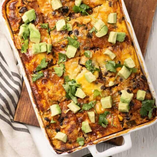 Cheesy baked Mexican casserole topped with avocado and cilantro.