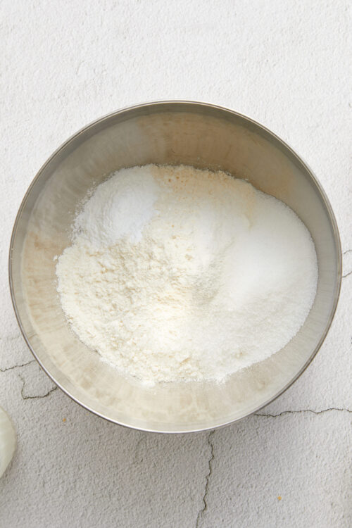 Flour, sugar, and baking ingredients in a mixing bowl for baking recipes.