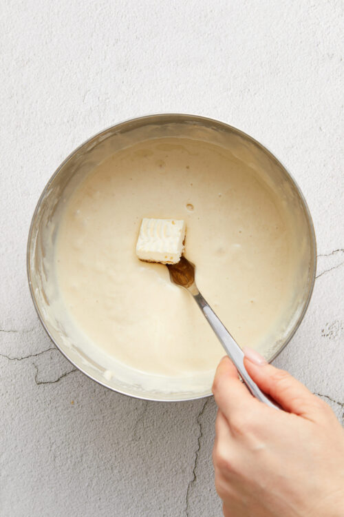 Creamy butter and milk mixture in a mixing bowl for baking recipes.