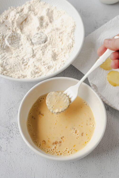 Flour and egg mixture for baking on a textured white surface.