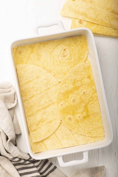 Golden baked tortilla chips in a white baking dish.