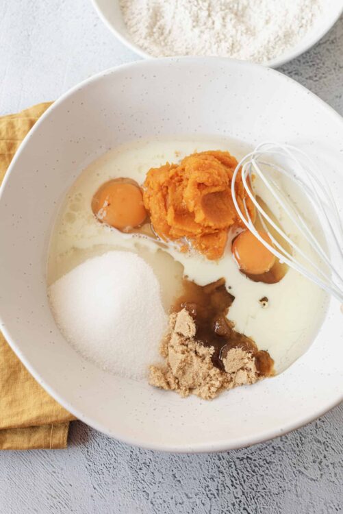 Flour, sugar, and sweet potato for baking or cooking in a white mixing bowl.