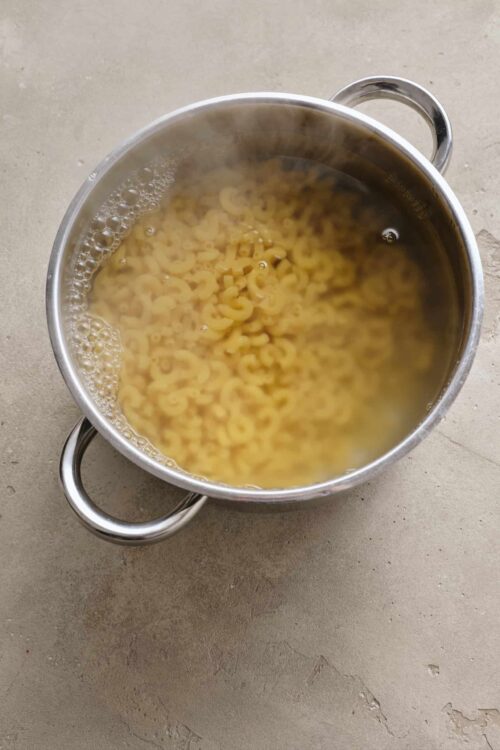 Cooked elbow macaroni pasta in a stainless steel colander.