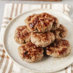 Juicy homemade meatballs with a savory glaze on white ceramic plate. Perfect for Italian dinner or family recipe.