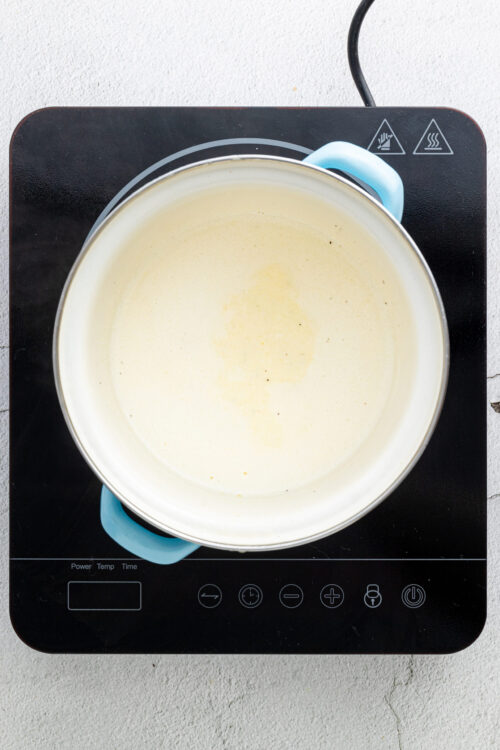 Cream being heated on an electric stove for baking or cooking.