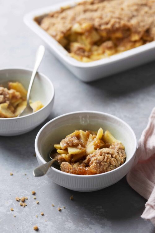 Butterfinger apple crumble, homemade dessert with caramel apples, crumb topping, baked apple crisp, cozy fall dessert.