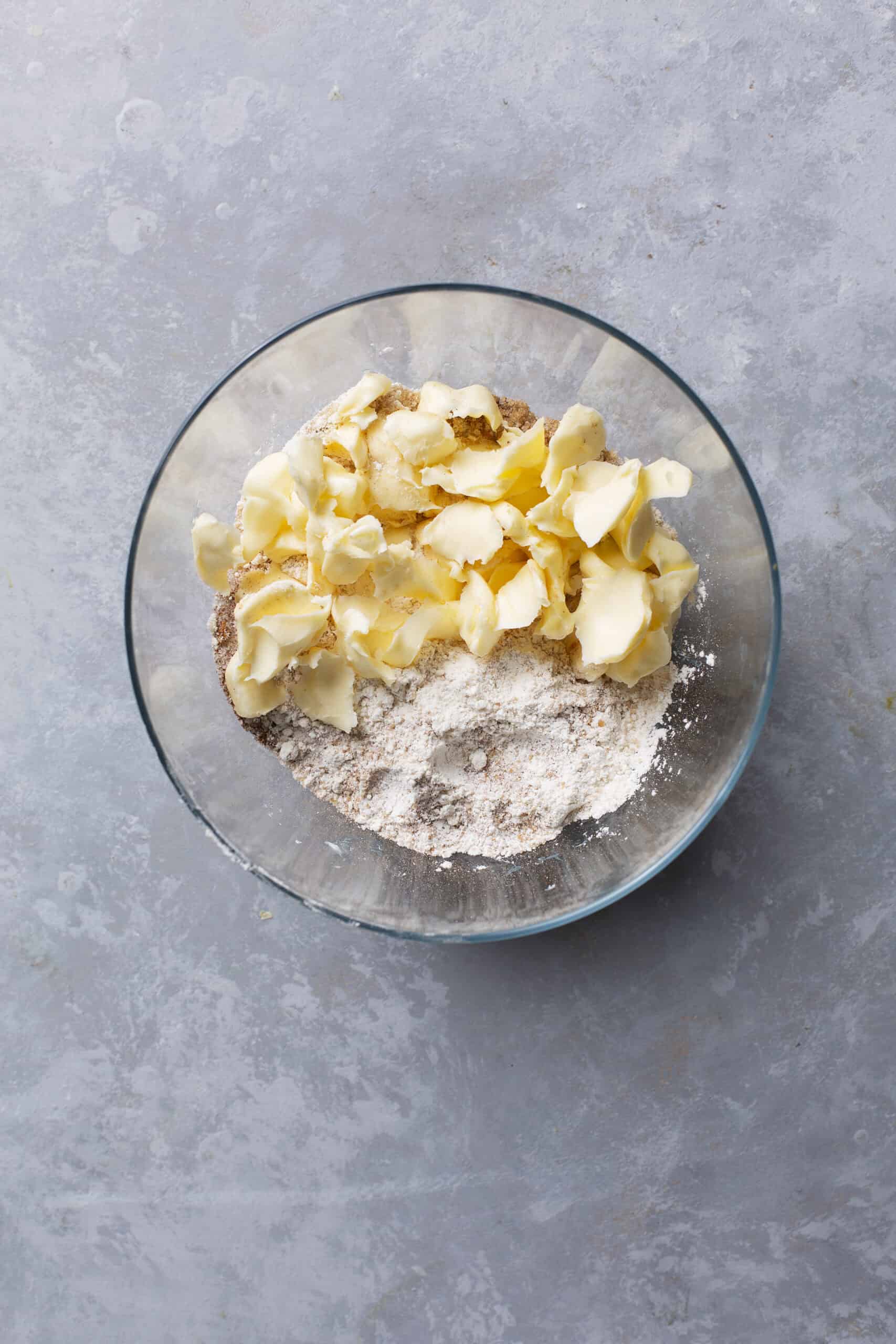 Flour, butter, sugar for baking in a glass bowl with ingredients ready for pastry or cake preparation.