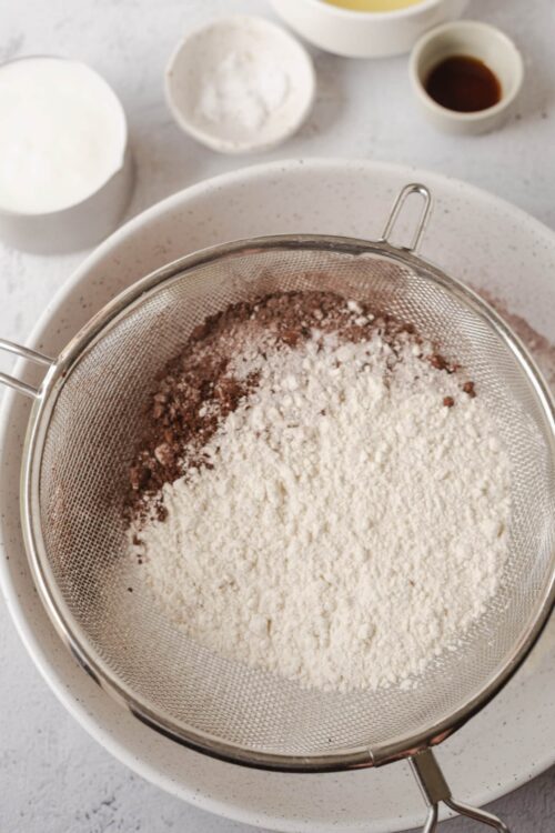 Flour and cocoa powder sifted together in a baking sifter for cake or pastry preparation.